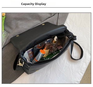 Macro view of the spacious inner compartment of the black quilted crossbody bag