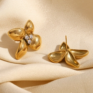 Macro view of 18K gold plated four-petal flower earrings with micro-set white crystals