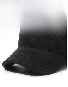 Detailansicht der Wolltextur und des metallenen F&S-Logos auf dieser grauen Flatcap