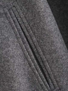 Gros plan des coutures fines et du lainage gris d'un blouson bomber souple