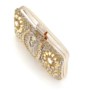 Detail of evening clutch bag featuring intricate gold and clear crystal rhinestone inlay