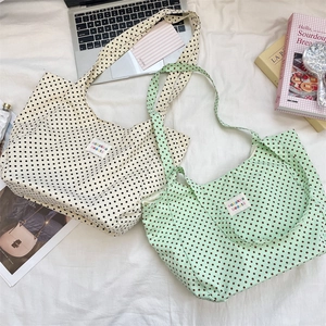 Close-up of canvas tote bags with polka dot patterns and woven label detailing