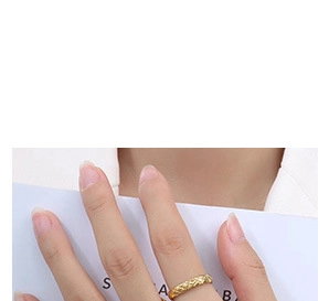 Close-up of 18K gold ring featuring quilted pattern engraving on hand