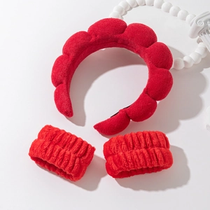 Detail view of red microfiber cloud headband and matching wristbands for skincare