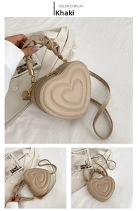 Macro detail of khaki heart-shaped bag featuring pleated handle and gold hardware