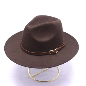 Dettaglio di cappello fedora in lana marrone con cinturino in pelle e fibbia dorata