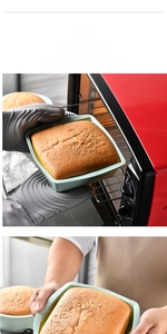 Close-up of food-grade green silicone baking mold being pulled from an oven with toast