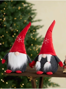 Close-up of two Christmas gnomes with retractable legs on a rustic wooden table