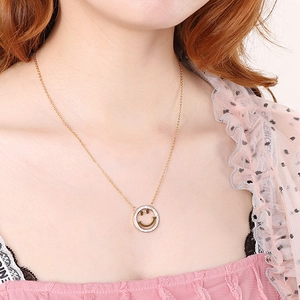 Elegant gold smiley face necklace with sparkling crystals shown on a female model neck