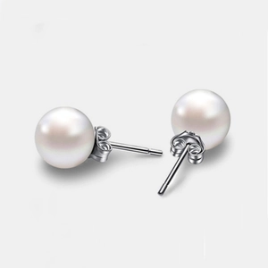 Elegant s999 sterling silver stud earrings featuring high-luster white pearls on white background