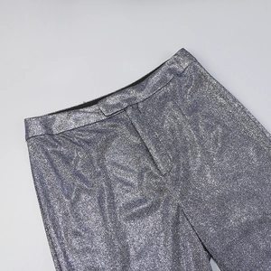 Detail of silver blue sequined pants showing high waist cut and shimmering fabric texture