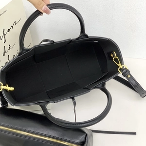 Top view of black woven tote bag interior showing the inner pouch and metal hardware