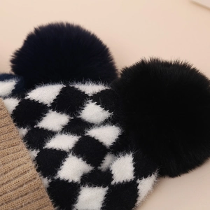 Cozy winter checkerboard knit baby hat with two large black faux fur pom-poms for warmth