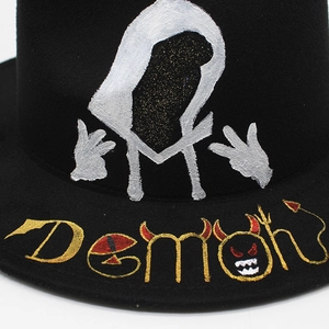 Detailed view of hand-painted white silhouette and Demon text on a black felt fedora hat
