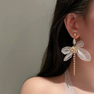 Detail view of mesh flower earrings with pearl drop and long tassel on model