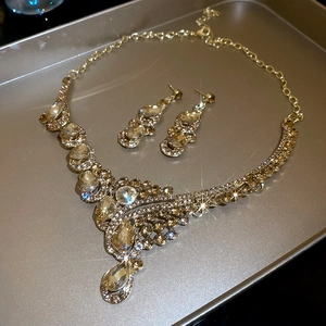 Macro shot of gold jewelry set with champagne rhinestones and fringe water drop necklace