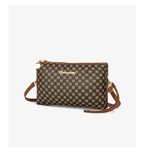 Close-up of golden polka dot pattern and metal logo on brown leather crossbody bag
