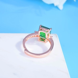 Detailed 45-degree angle of emerald cut ring in rose gold finish with marble background