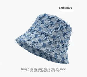 Detail of light blue checkered denim bucket hat featuring frayed edges and vintage texture
