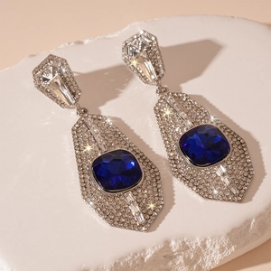Macro shot of geometric silver earrings with blue crystals and sparkling rhinestones