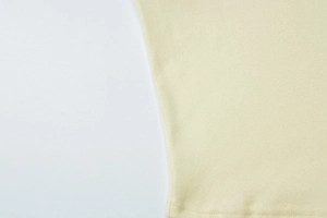 Detailed macro view showing flat stitching and texture of light yellow knit cardigan
