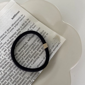 Detail showing the seamless texture and durable knit design of the black elastic hair tie