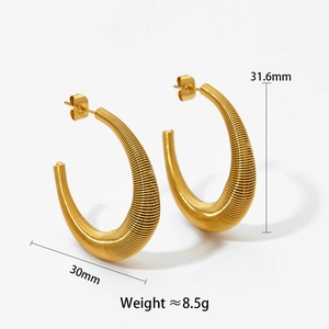 Macro detail of gold twisted C-shape hoop earrings showing ribbed texture and 30mm size