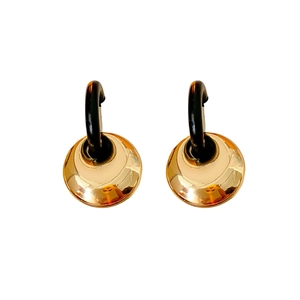 Elegant geometric gold and black hoop earrings with polished metallic finish on white background