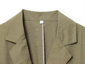 Gros plan du col de veste vert armée montrant les coutures et l'étiquette de taille S