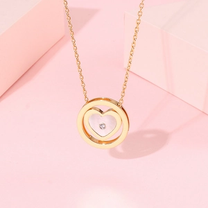 Élégant collier pendentif cœur doré avec zircon scintillant sur fond esthétique rose