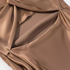 Macro shot of bronze satin fabric showing glossy texture and high-quality sewing detail