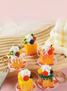 Nahaufnahme verschiedener Mini-Obstkuchen-Schlüsselanhänger aus Harz mit Goldring