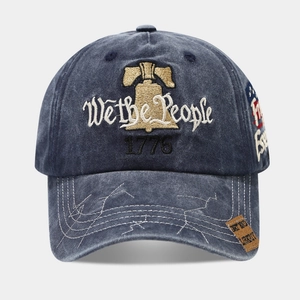 Close-up of Liberty Bell embroidery and 'We the People' script on washed denim cap