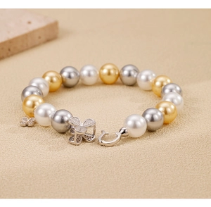 Macro shot of 925 silver clover bracelet with colorful pearls and butterfly charms