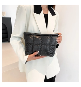 Detailaufnahme der schwarzen gesteppten Clutch mit bauschigen quadratischen Mustern