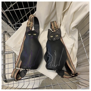 Close-up of cat-shaped shoulder bags featuring purple and silver embroidery and striped straps