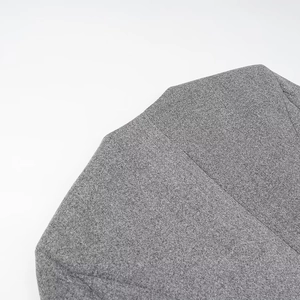 Close-up of grey blend wool fabric showing double-breasted button details on the coat