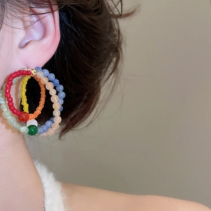 Detail of colorful multilayered beaded hoop earrings with bohemian ethnic style design