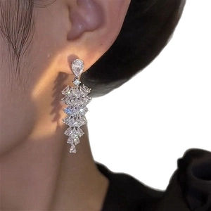 Elegant silver drop tassel earrings with sparkling zircon crystals on a model