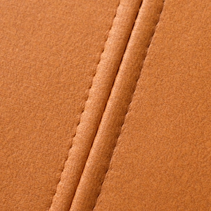 Macro shot of orange tech fabric pillow cover with detailed double stitching and texture