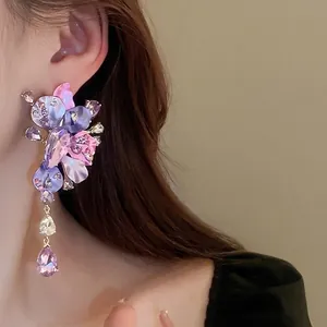 Exaggerated purple floral crystal drop earrings with silver needle shown on a model