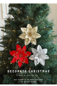 Three-layer glitter poinsettia flowers hanging on a glowing Christmas tree