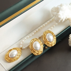Elegant gold titanium jewelry set with oval pearls in green gift box with white coral