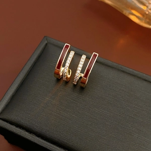 Détail de boucles d'oreilles en U avec émail bordeaux et zircone sur boîte noire