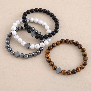 Detailed top view of natural stone beaded bracelets with metallic cross pendants