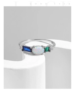 Close-up of S925 silver ring with white opal and colorful gems on white props