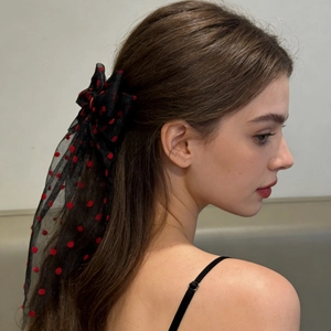Detail of red heart-pattern mesh bow hair clip on model for a romantic hair accessory style