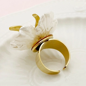 Detail of elegant gold plated stainless steel open ring with 3D white resin flower petals