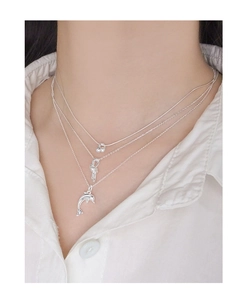 Three-layered S925 silver necklace with cherry, knot, and dolphin charms on a model