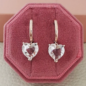 Rose gold hoop earrings with heart-shaped clear zircons on pink velvet jewelry box